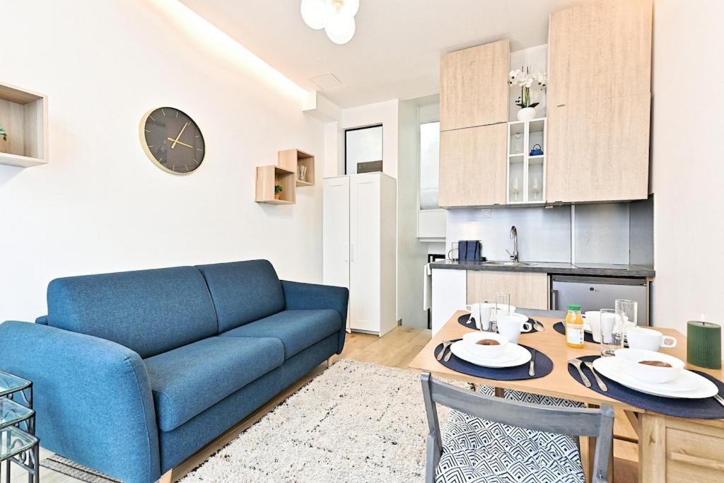 un salon avec un canapé bleu et une table dans l'établissement Duplex agréable et comfortable dans le 9ème, à Paris