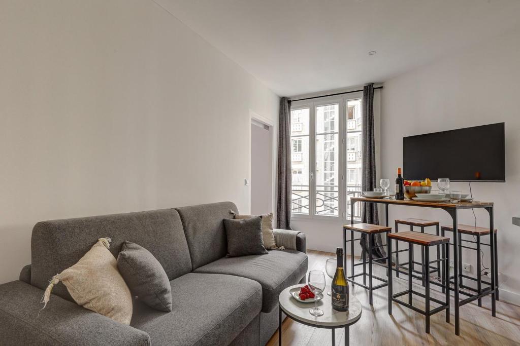 un salon avec un canapé et une télévision dans l'établissement 5005 Suite Dardou - Nice apartment Palais Congrès, à Paris