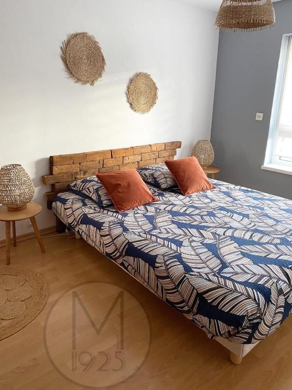 - une chambre avec un lit doté d'une tête de lit en bois et d'oreillers dans l'établissement Maison 1925, Méricourt 62, à Méricourt