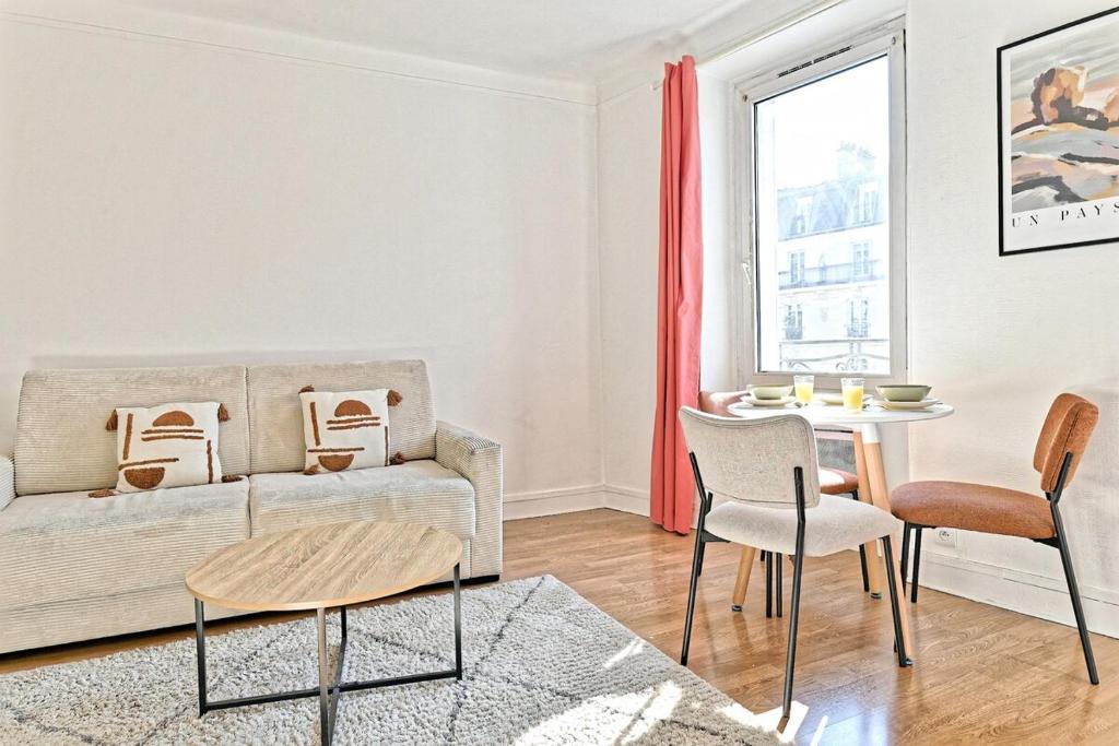 un salon avec un canapé et une table dans l'établissement Studio cosy et lumineux proche de Nation Voltaire, à Paris
