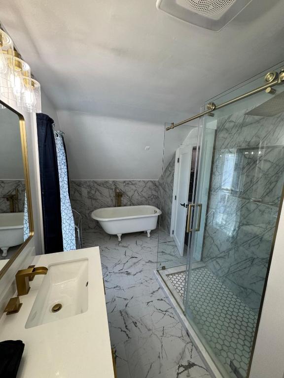 a bathroom with a shower and a sink and a tub at The Captains Perch in Stonington
