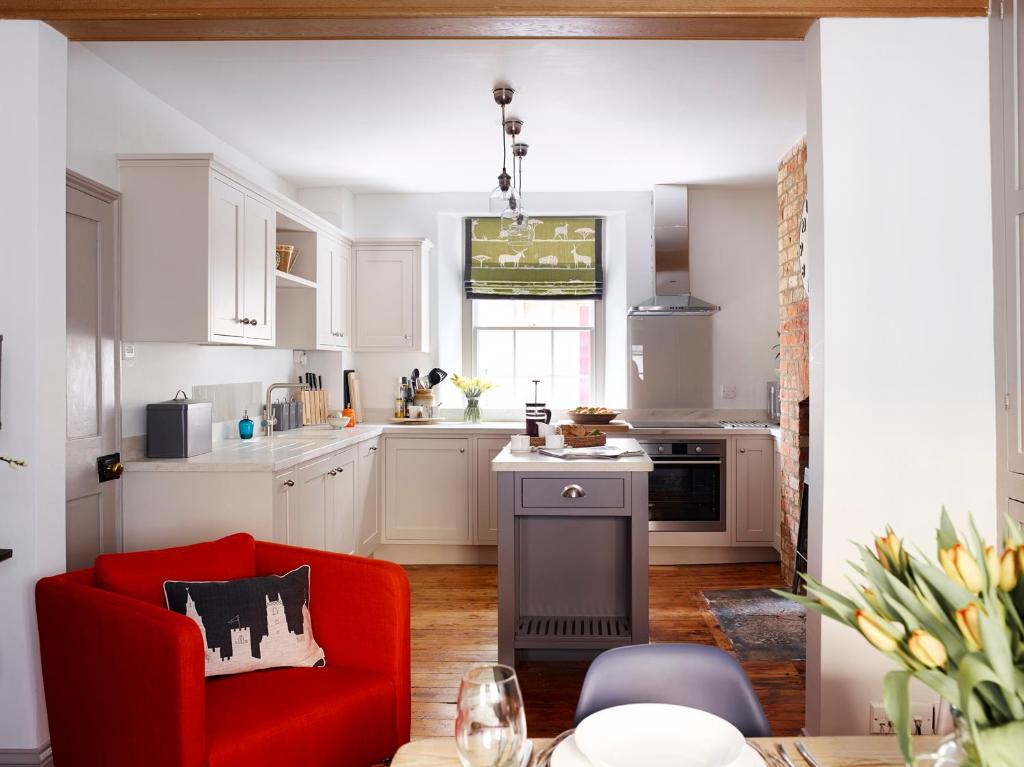 a kitchen with a red couch and a red chair at Park Gate in Stamford