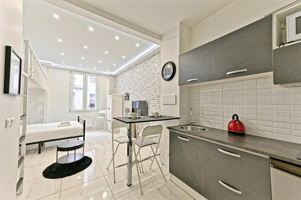 une cuisine avec un évier et un plan de travail dans l'établissement Studio Cosy Proche de Montmartre Charme du 18e, à Paris
