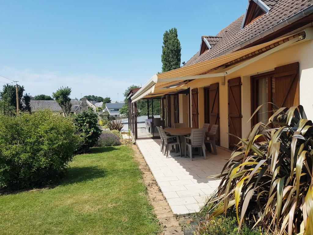 un patio d'une maison avec une table et des chaises dans l'établissement L'Escale - Family home, à Granville