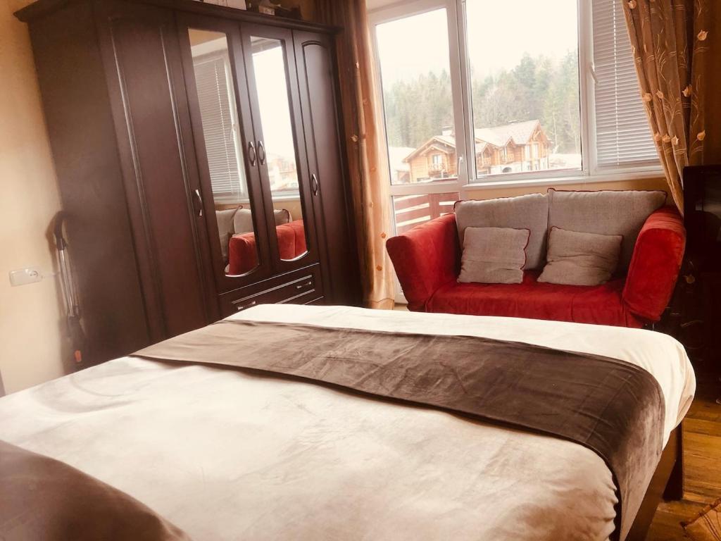 1 dormitorio con 1 cama y 1 sofá en la ventana en Mziuri Velli, en Bakuriani