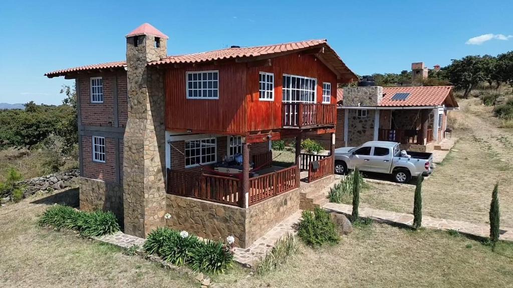 a house with a truck parked in front of it at Cabañas San José de la Montaña in Mazamitla