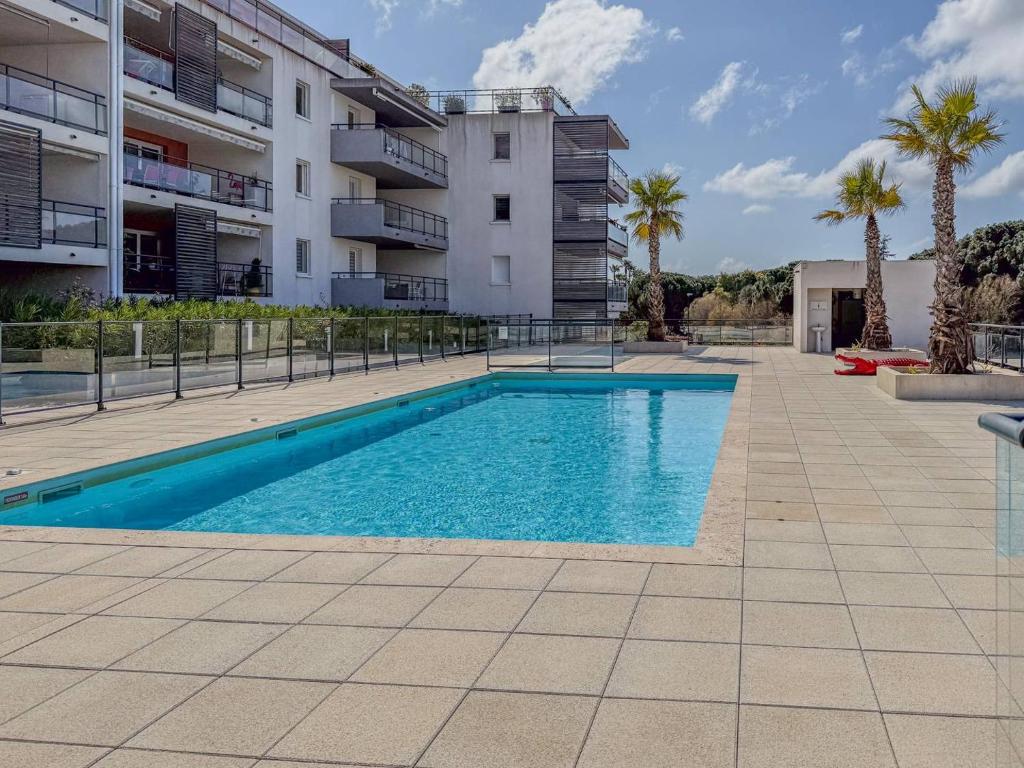 une piscine devant un immeuble dans l'établissement T2 Résidence EDEN, Piscine , Idéale pour une famille de 4 personnes, au Lavandou