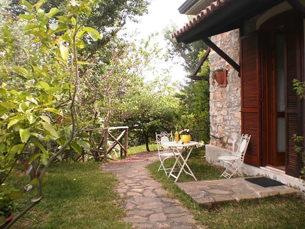 un patio con mesa y sillas junto a una casa en La Gabbianella e il Gatto en Castellabate