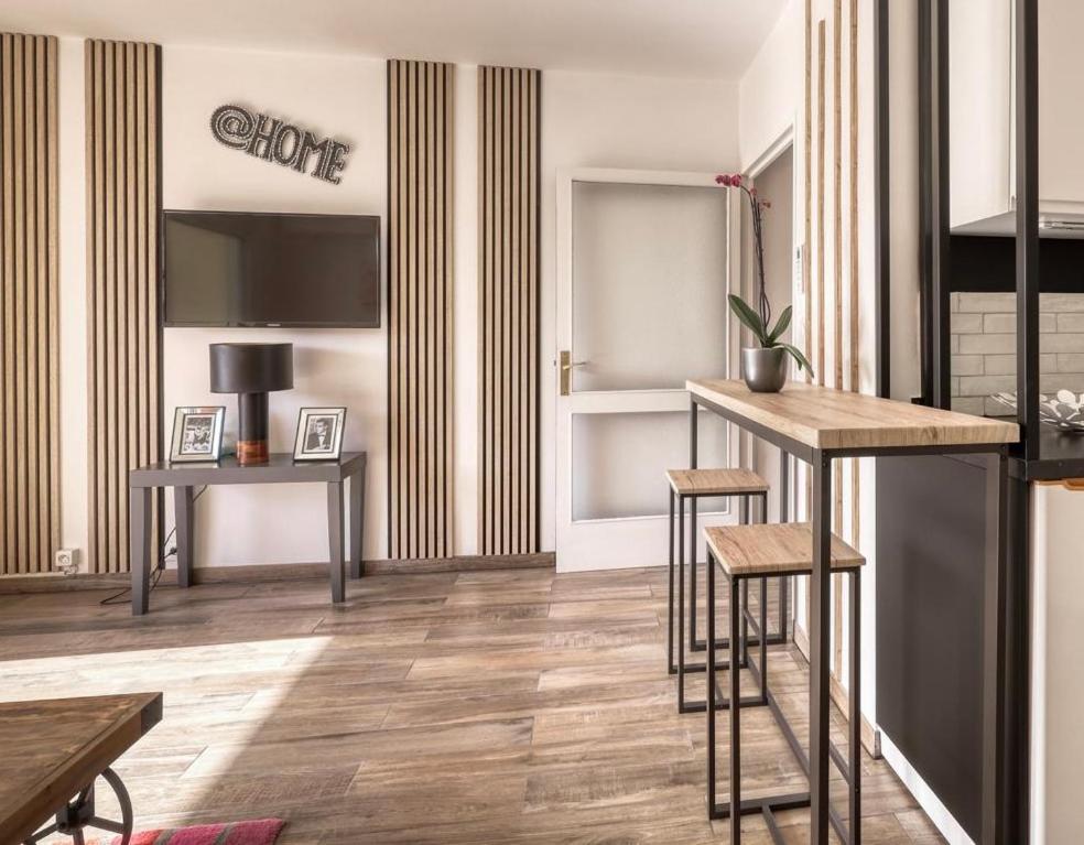 - un salon avec deux tables et deux tabourets dans l'établissement Studio neuf bord de mer Le Lavandou - Piscine - Tennis - Boulodrome dans la résidence, au Lavandou