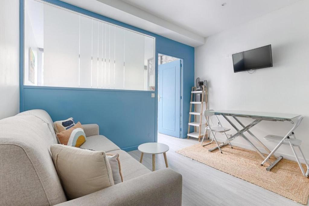 un salon avec un canapé et une table dans l'établissement Charming apartment Gambetta - Saint Fargeau II, à Paris