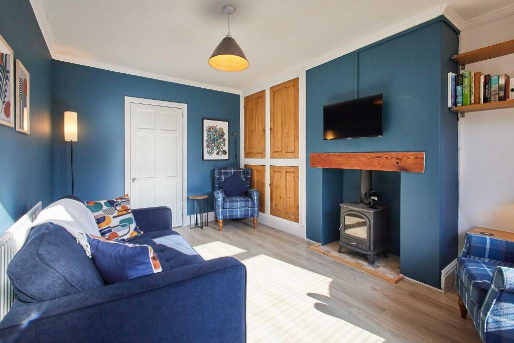 a blue living room with a couch and a fireplace at Host & Stay - Wellington Street in Ripon