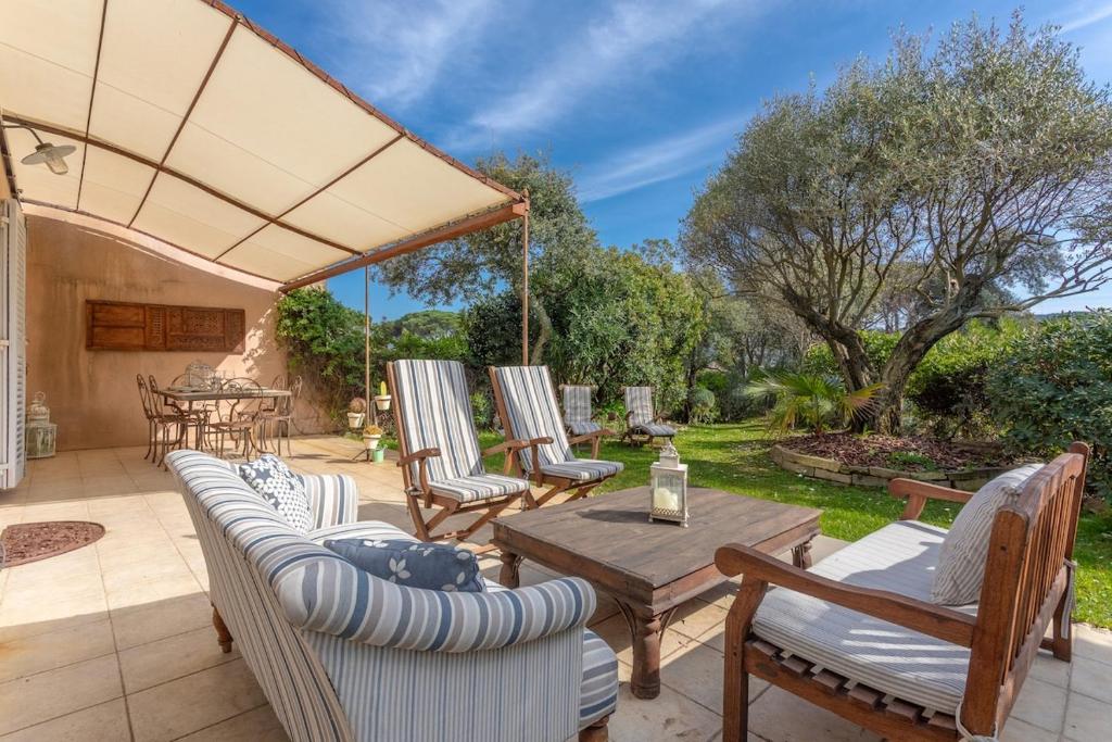 une terrasse avec des canapés, une table et des chaises dans l'établissement Maison Longagne- Jardin, Piscine, 2 chambres, à Gassin