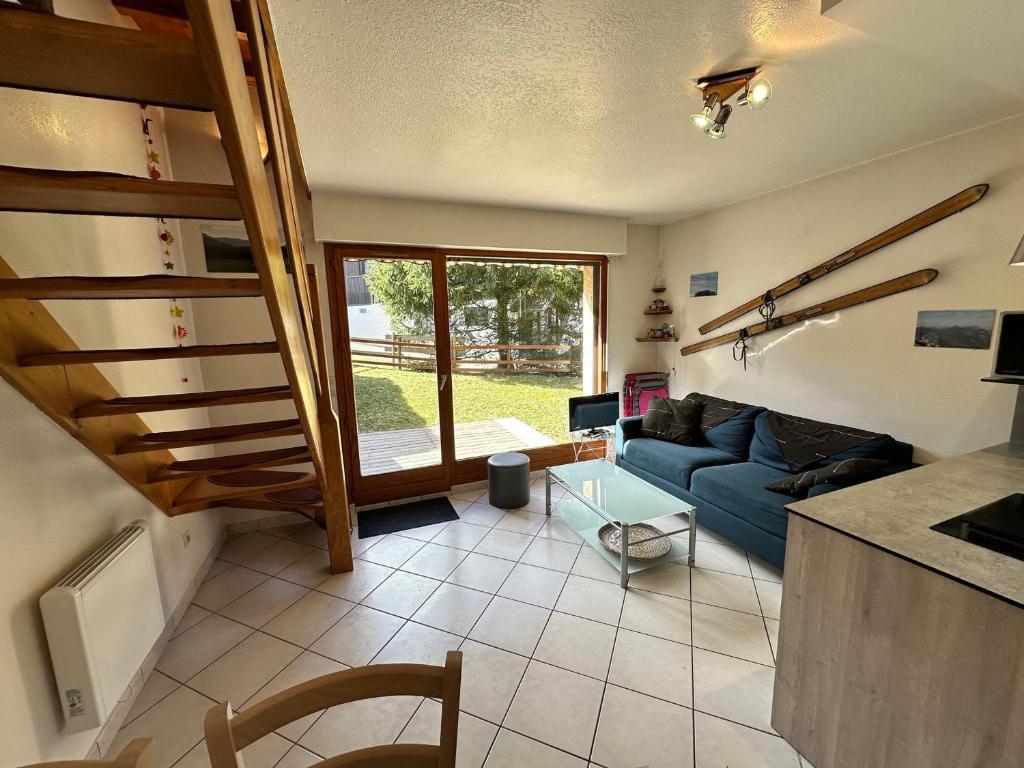 - un salon avec un canapé bleu et un escalier dans l'établissement Charmant Duplex de 45m², 2 Chambres, Jardin, Garage, Villard-de-Lans - FR-1-515-51, à Villard-de-Lans