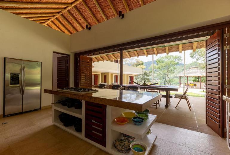a large kitchen with a counter and a table in it at Astonishing 5BR House with pool in Anapoima in Anapoima