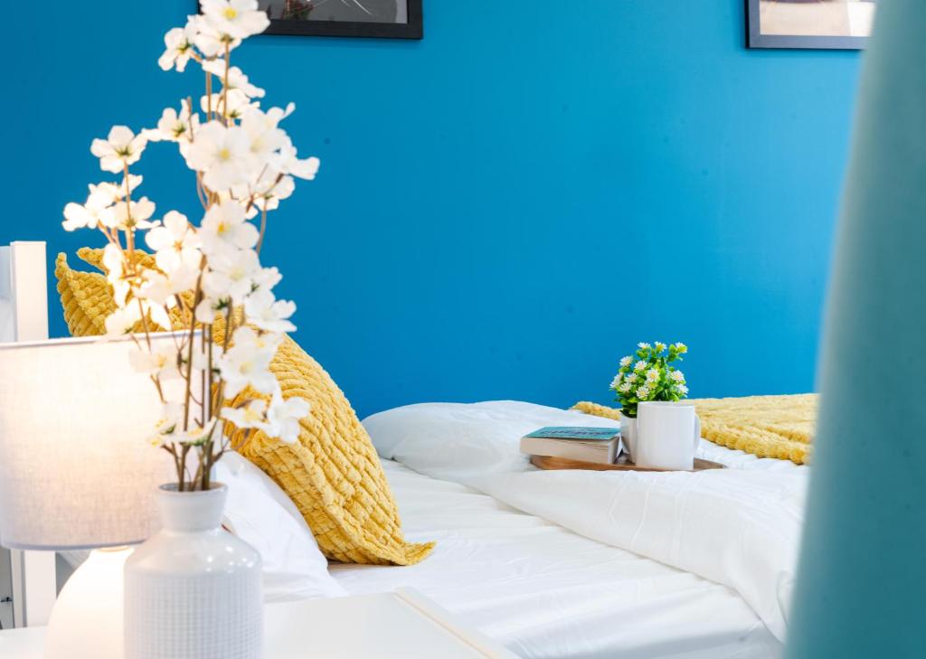 a bed with white sheets and a blue wall at Open Mind Property - Hot Tub, 8 Guests & Free Parking in Portsmouth