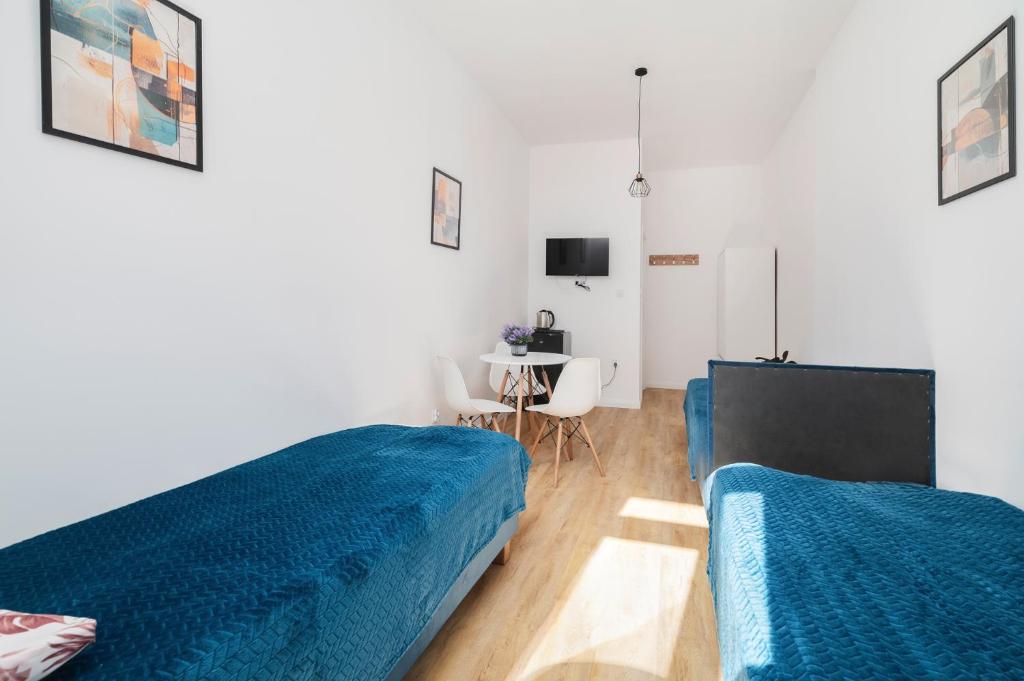 a bedroom with two blue beds and a desk at Centrum 5 Łódź 7 Próchnika 21 in Łódź