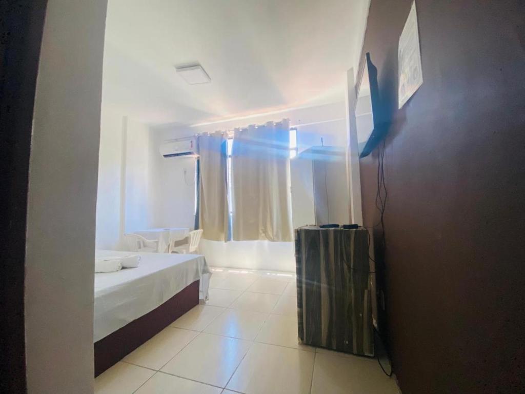 ein weißes Zimmer mit einem Bett und einem Fenster in der Unterkunft hotel praia itapua in Salvador