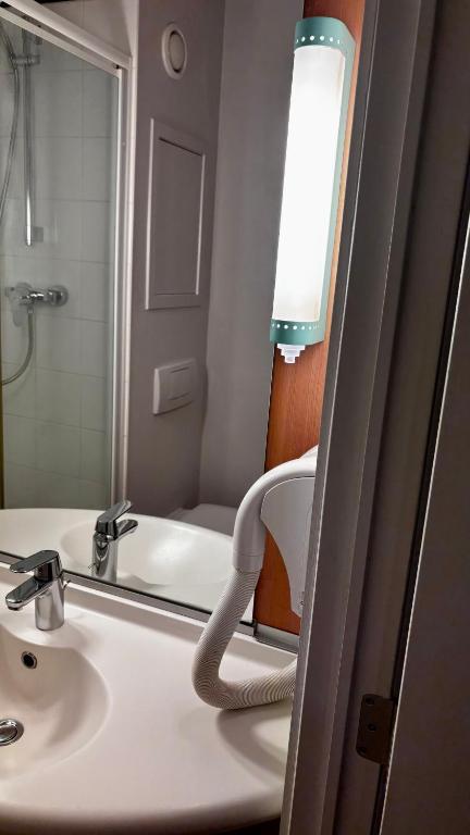a bathroom with a sink and a mirror at ibis Dinant Centre in Dinant