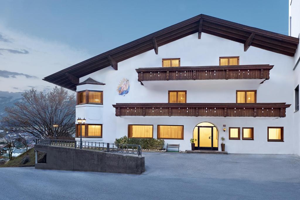 une grande maison blanche avec une porte jaune dans l'établissement Muttererhof, à Innsbruck