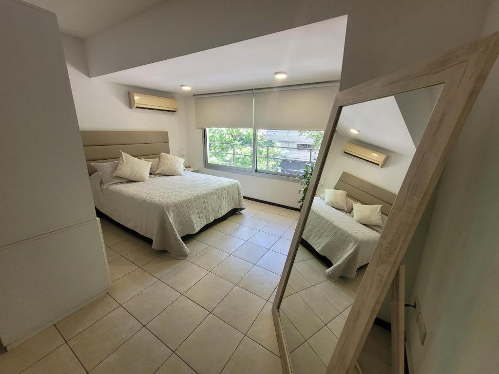 a bedroom with two beds and a mirror at Monoambiente13 Zona Catedral by Lofter in La Plata