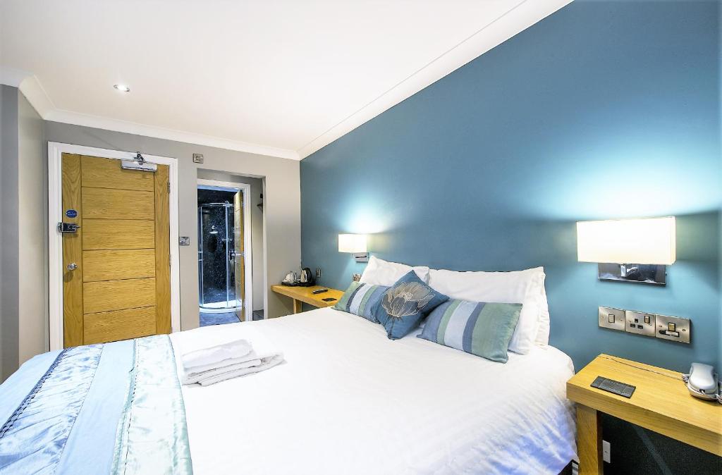 a bedroom with a large bed with blue walls at Dolphin Rooms in Cleethorpes