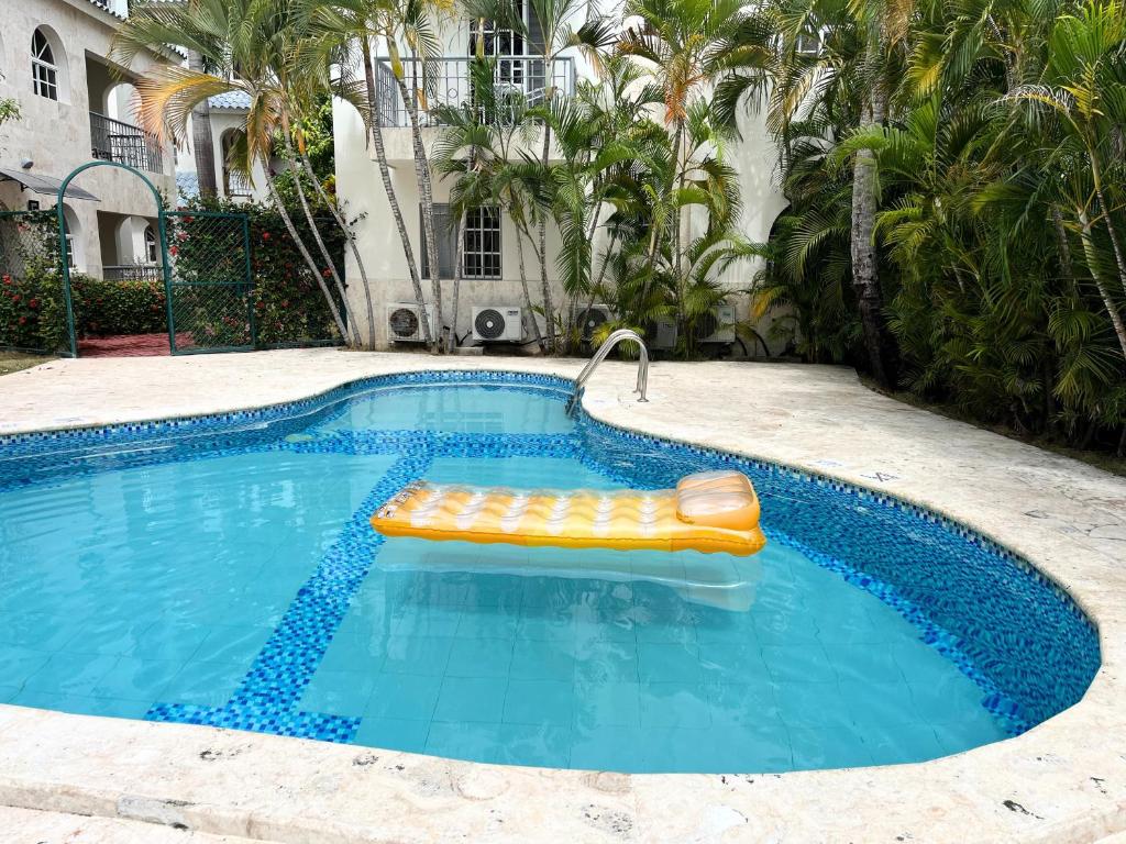 una piscina con una balsa en el medio en Cozy Condo - 4 min to the Beach, en Punta Cana