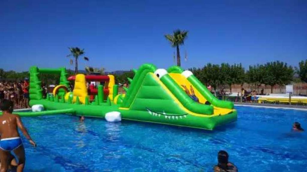 a group of people in a swimming pool with a water slide at ZEcamping 3 familial piscine club enfant animaux acceptés animations in Malgrat de Mar