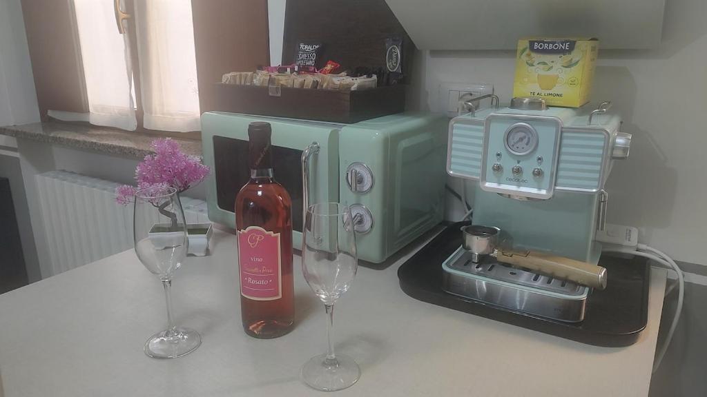 eine Theke mit zwei Weingläsern und einer Kaffeemaschine in der Unterkunft Two-room apartment in Voghera's historic center in Voghera