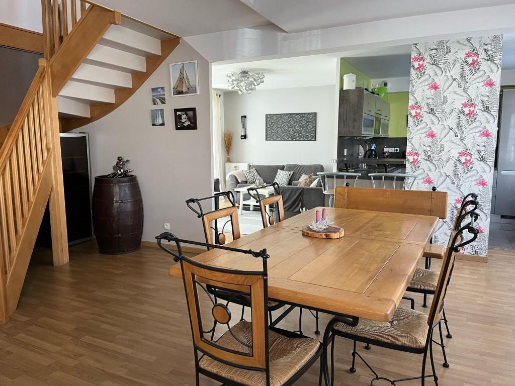 a wooden table and chairs in a living room at Villa Hésperides 5 mins de Disneyland Paris in Magny-le-Hongre