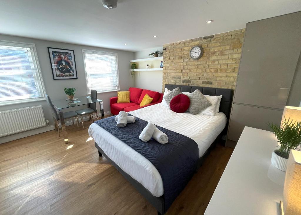 a bedroom with a large bed and a red couch at Luxury Apartment with King-size Bed in Central Cambridge - Walk to Station and City Centre in Cambridge