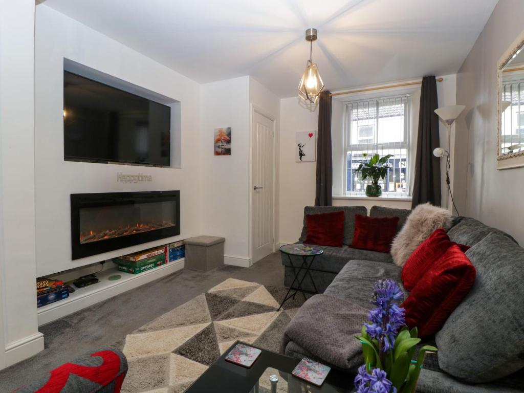 a living room with a couch and a fireplace at Colliers Cottage in Cinderford