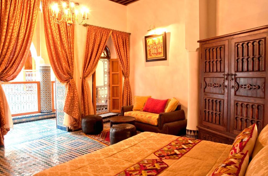 een slaapkamer met een bed, een stoel en een raam bij Riad-Boutique Borj Dhab Fez in Fès
