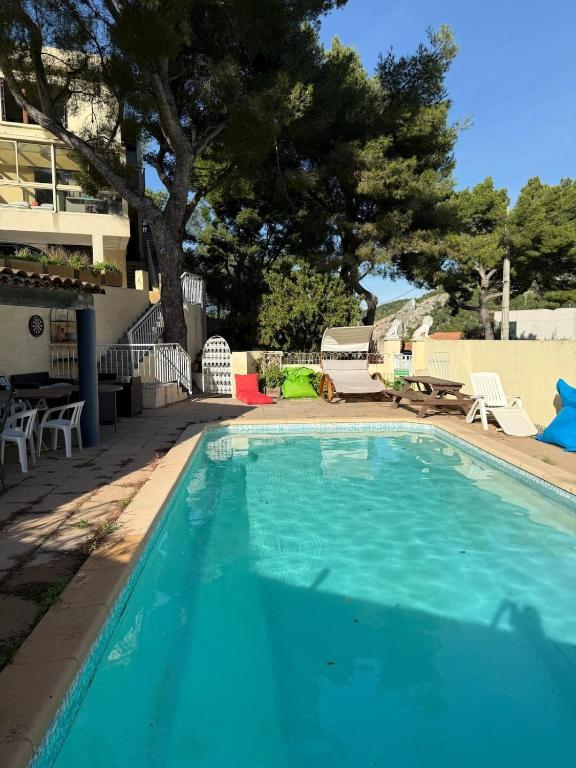 une piscine bleue avec un arbre en arrière-plan dans l'établissement Villa close to Calanques, à Marseille