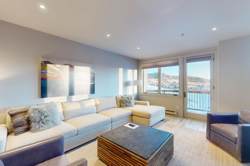 una sala de estar con un sofá y una mesa en Torian Plum Creekside 714, en Steamboat Springs