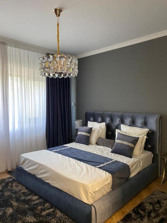 a large bed in a bedroom with a chandelier at LY Studio Pipera in Voluntari