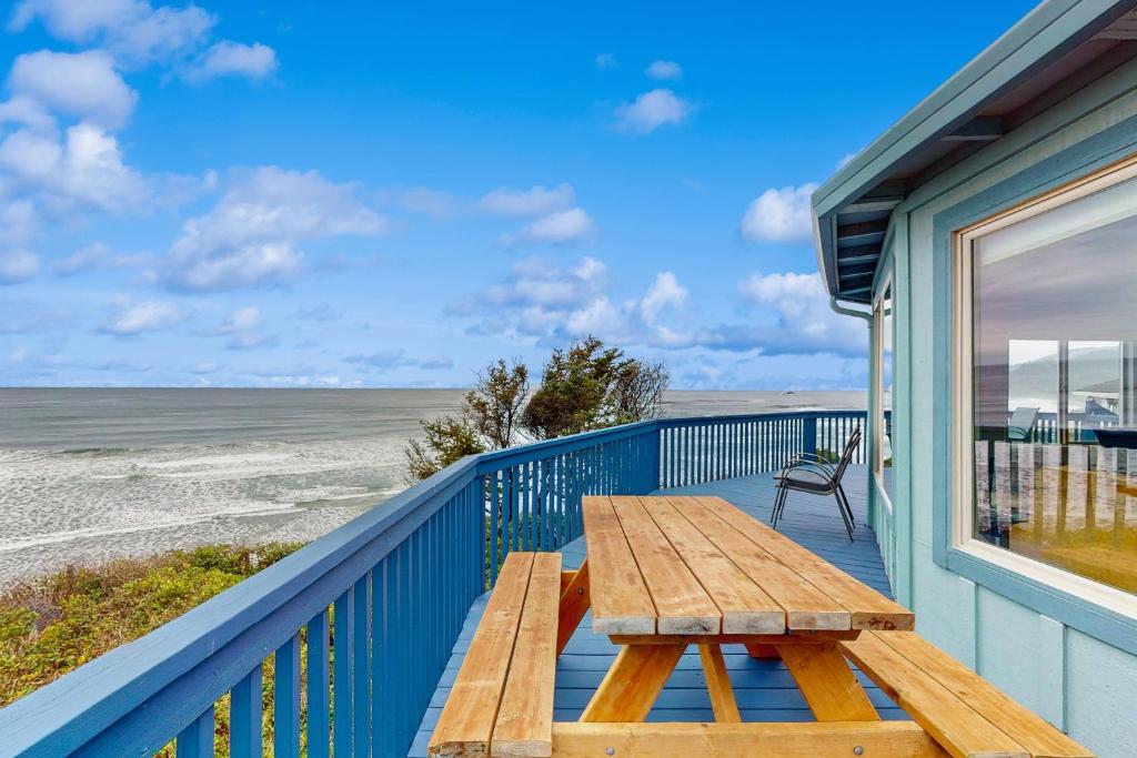 a picnic table on the balcony of a beach house at Waive Time in Lincoln City