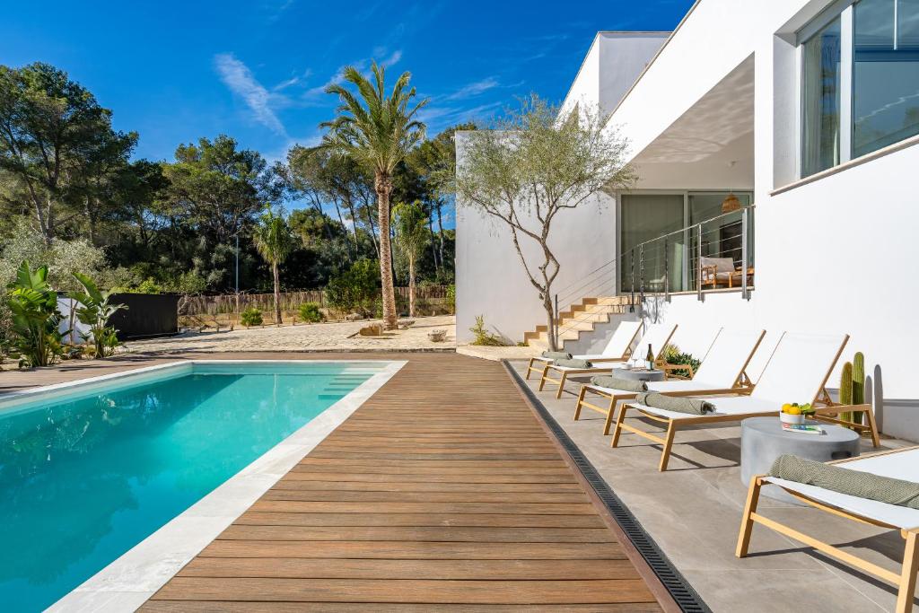 an image of a swimming pool with chairs and a house at Can Toni in Sa Pobla