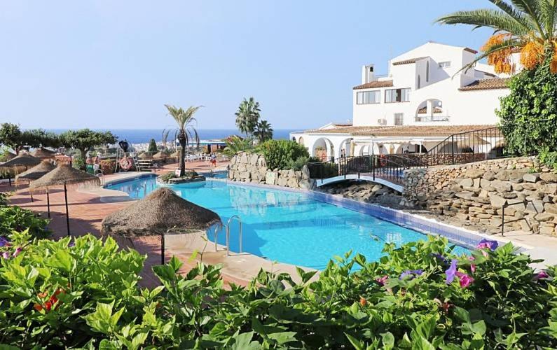 a large swimming pool next to a large building at CAPISTRANO BREEZE - Luxury Coastal Apartment in Capistrano Village, Nerja in Nerja