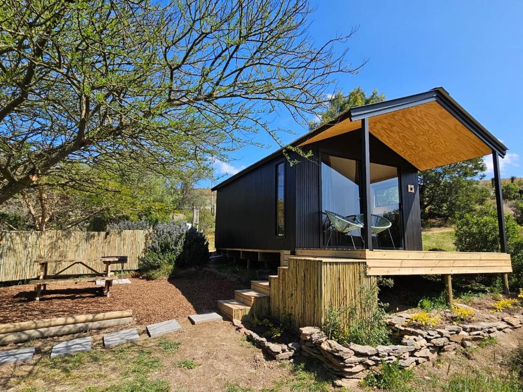 ein kleines schwarzes Haus mit Holzdach in der Unterkunft Fish Eagle River Camp in Vosburg