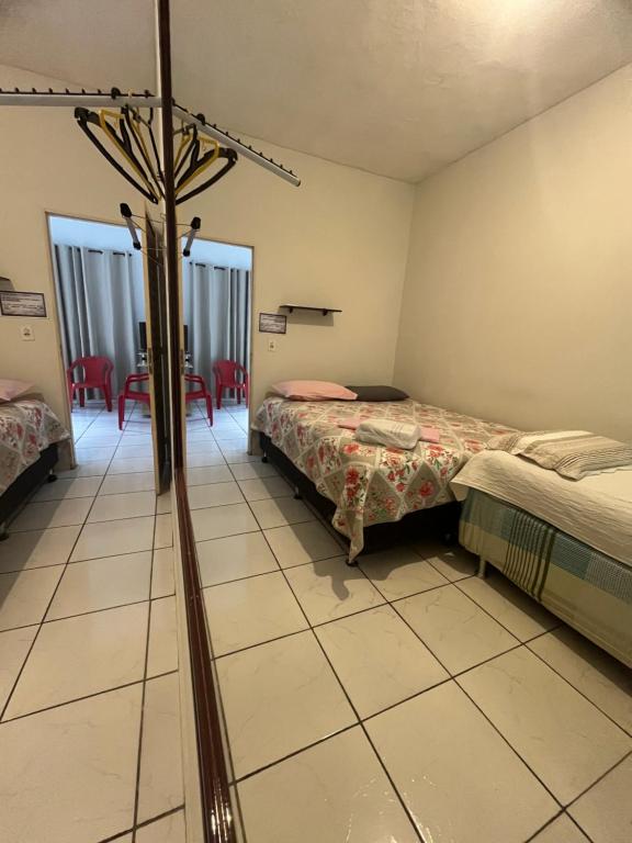 a room with two beds and a room with a bed at Hotel da Gaúcha in Aragarças