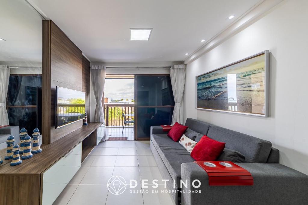 a living room with a gray couch and red pillows at Barra Bali - Pé na Areia, Vista Mar Incrível - Destino BSM 116 in Barra de São Miguel