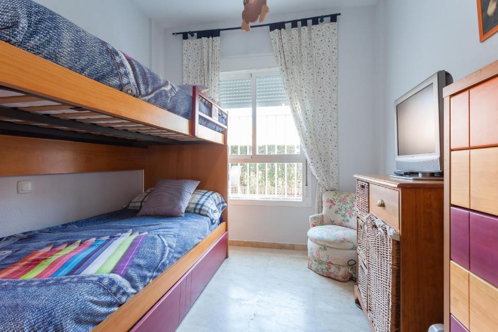 a bedroom with two bunk beds and a television at Divi Apartments Costa Ballena in Costa Ballena