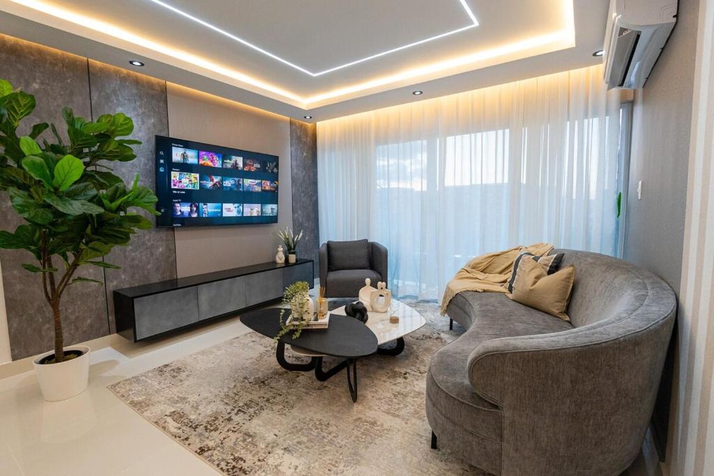 a living room with a couch and a table at Modern 3BR! 9FL, King Bed! STI with Pool! Fast wifi! in Santiago de los Caballeros