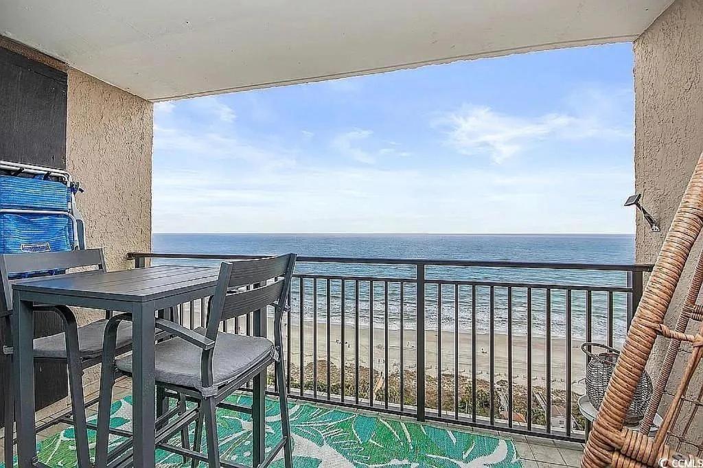 ein Balkon mit Tisch und Stühlen und dem Meer in der Unterkunft Coastal Comfort Your Perfect Beachfront Getaway in Myrtle Beach