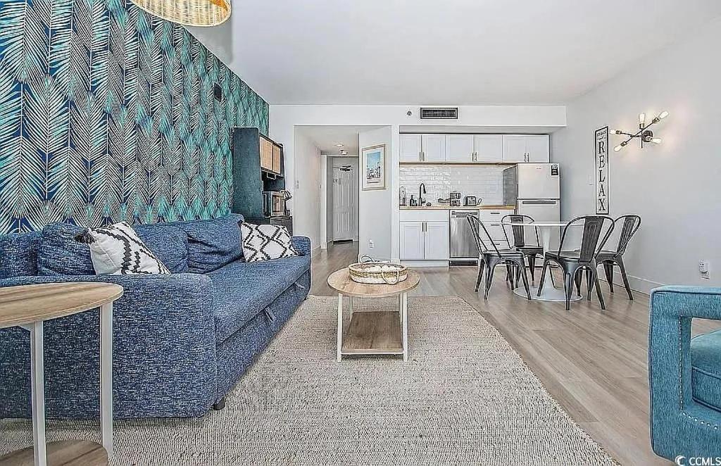 ein Wohnzimmer mit einer blauen Couch und einem Tisch in der Unterkunft Coastal Comfort Your Perfect Beachfront Getaway in Myrtle Beach