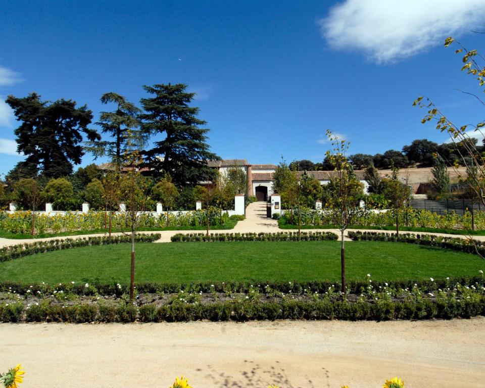 a large garden with a large building in the background at Caserio de Lobones in Segovia