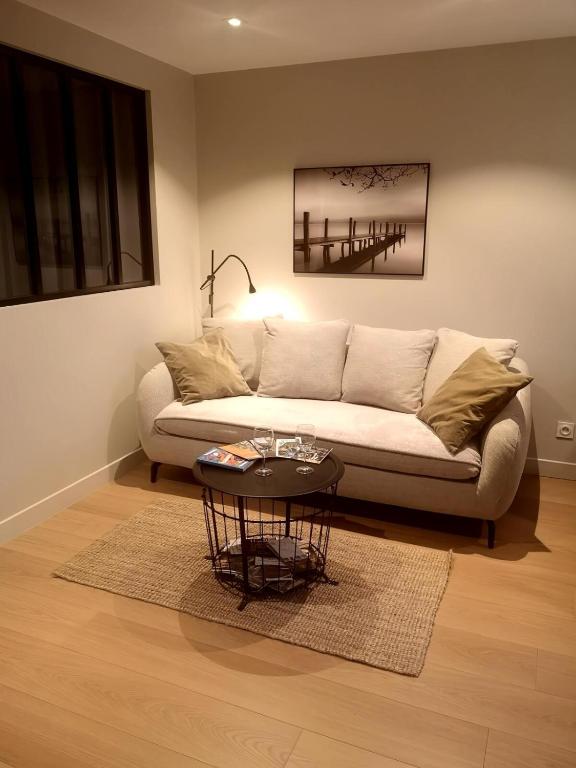 a living room with a couch and a table at Condrieu gîte climatisé parking privé in Condrieu
