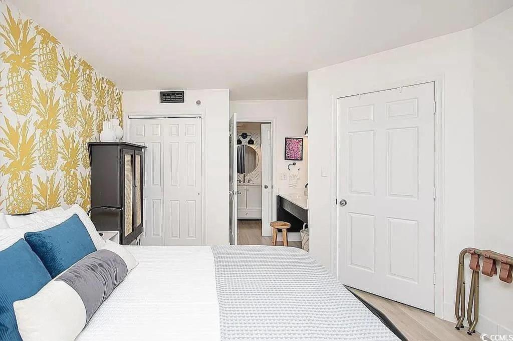 ein Schlafzimmer mit einem weißen Bett mit blauen Kissen in der Unterkunft Coastal Comfort Your Perfect Beachfront Getaway in Myrtle Beach