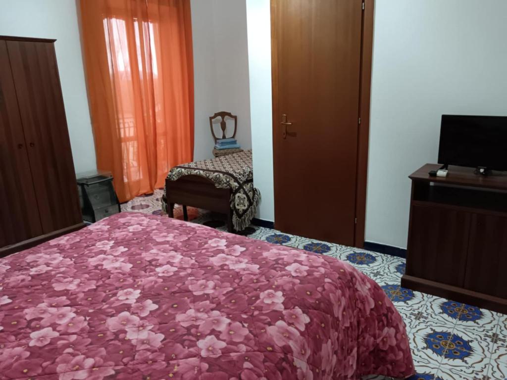 sypialnia z łóżkiem z różowym kocem w obiekcie AZIENDA AGRITURISTICA LA VECCHIA QUERCIA w mieście Aquino