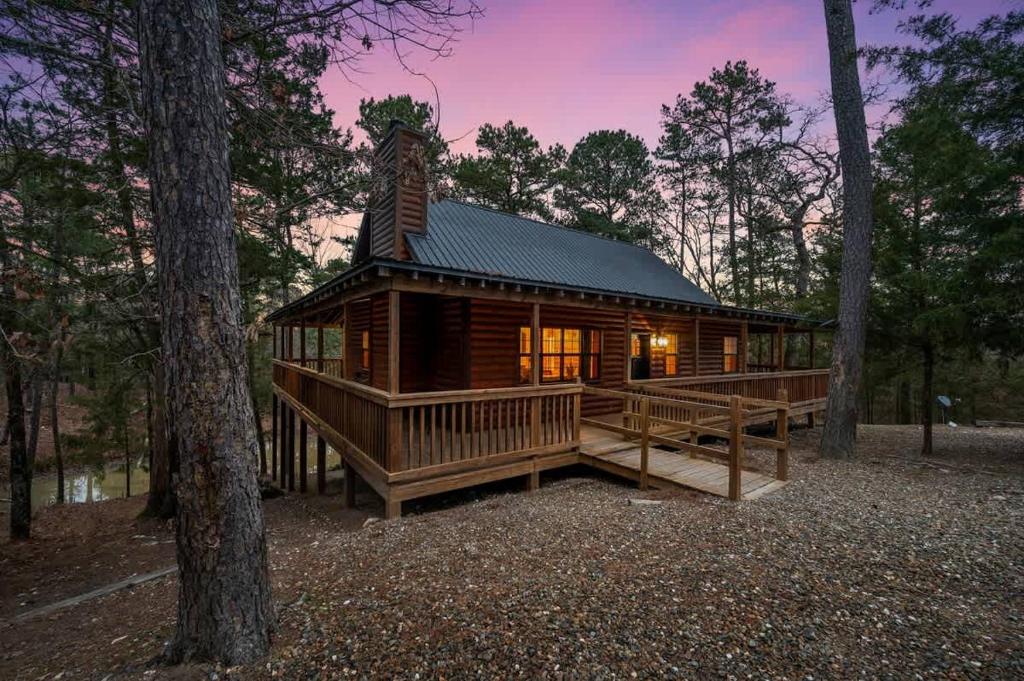 une cabane en rondins dans les bois avec un arbre dans l'établissement Sarah's Hideaway-Hot Tub Firepit & BBQ, à Stephens Gap